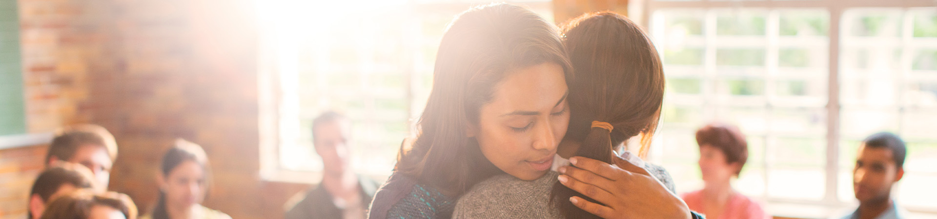 Two women hugging in treatment facility